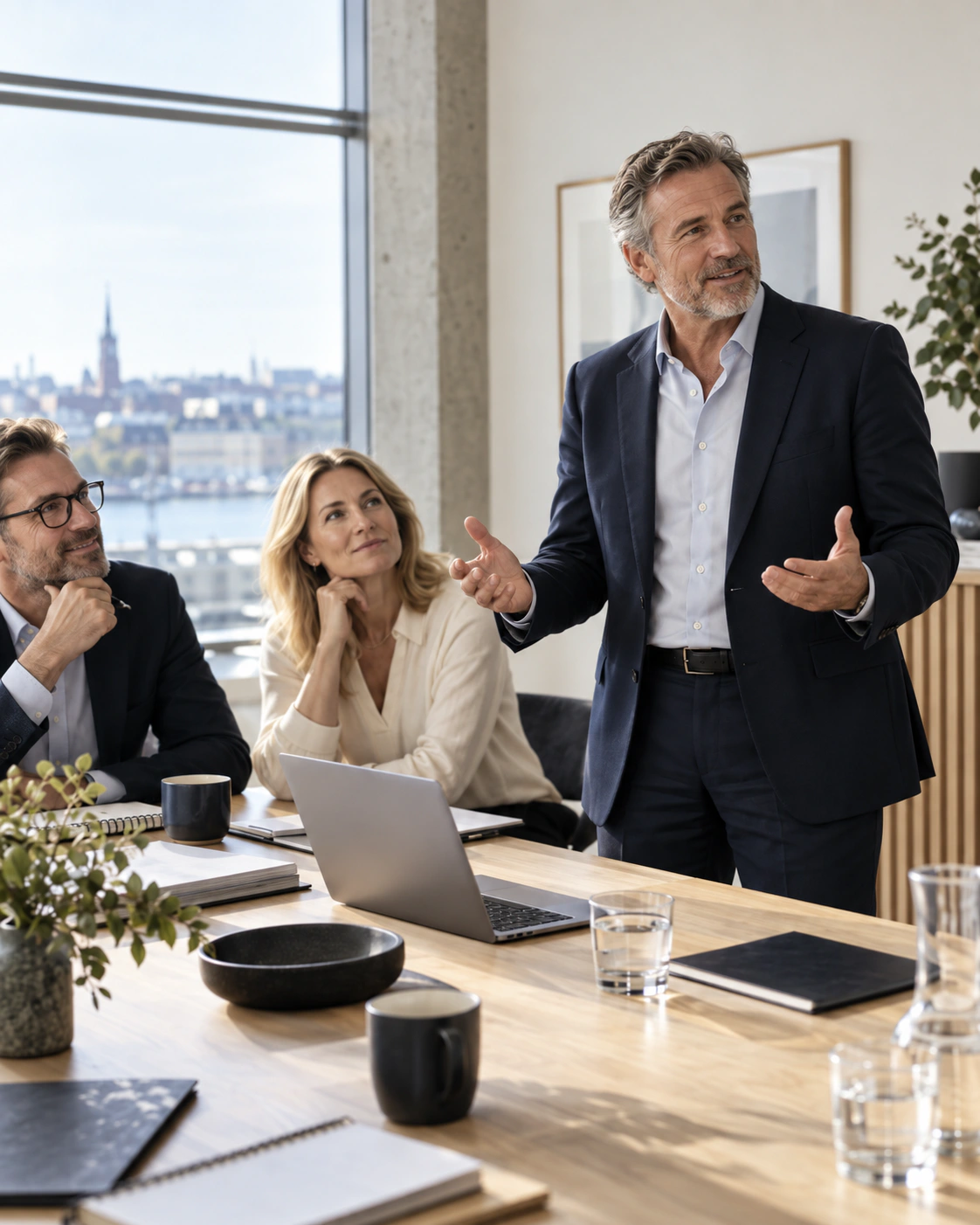 En erfaren manlig ledare driver ett strategiskt samtal framåt tillsammans med sitt team.
